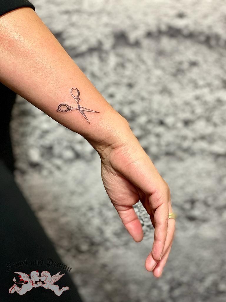 Fine line tattoo van een schaar