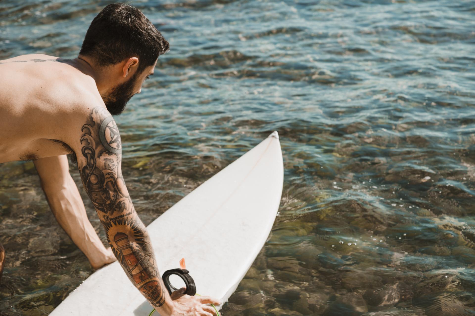 Nazorg tattoo zwemmen - man met tattoo gaat zwemmen